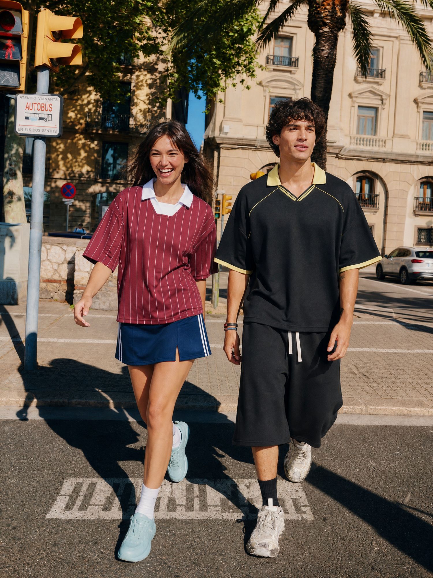 Models wearing football-inspired jerseys styled as everyday streetwear in an urban setting