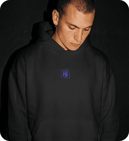 Creator wearing a black oversized hoodie in a lifestyle portrait.