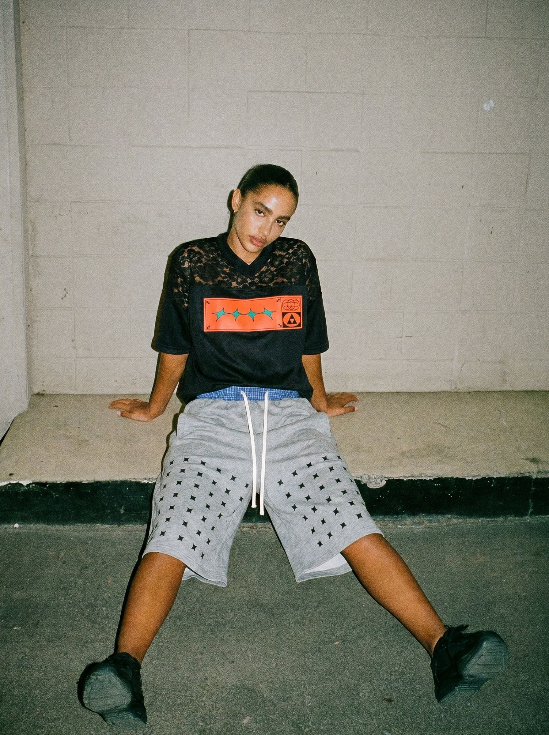 Model wearing a custom football-inspired jersey paired with casual shorts