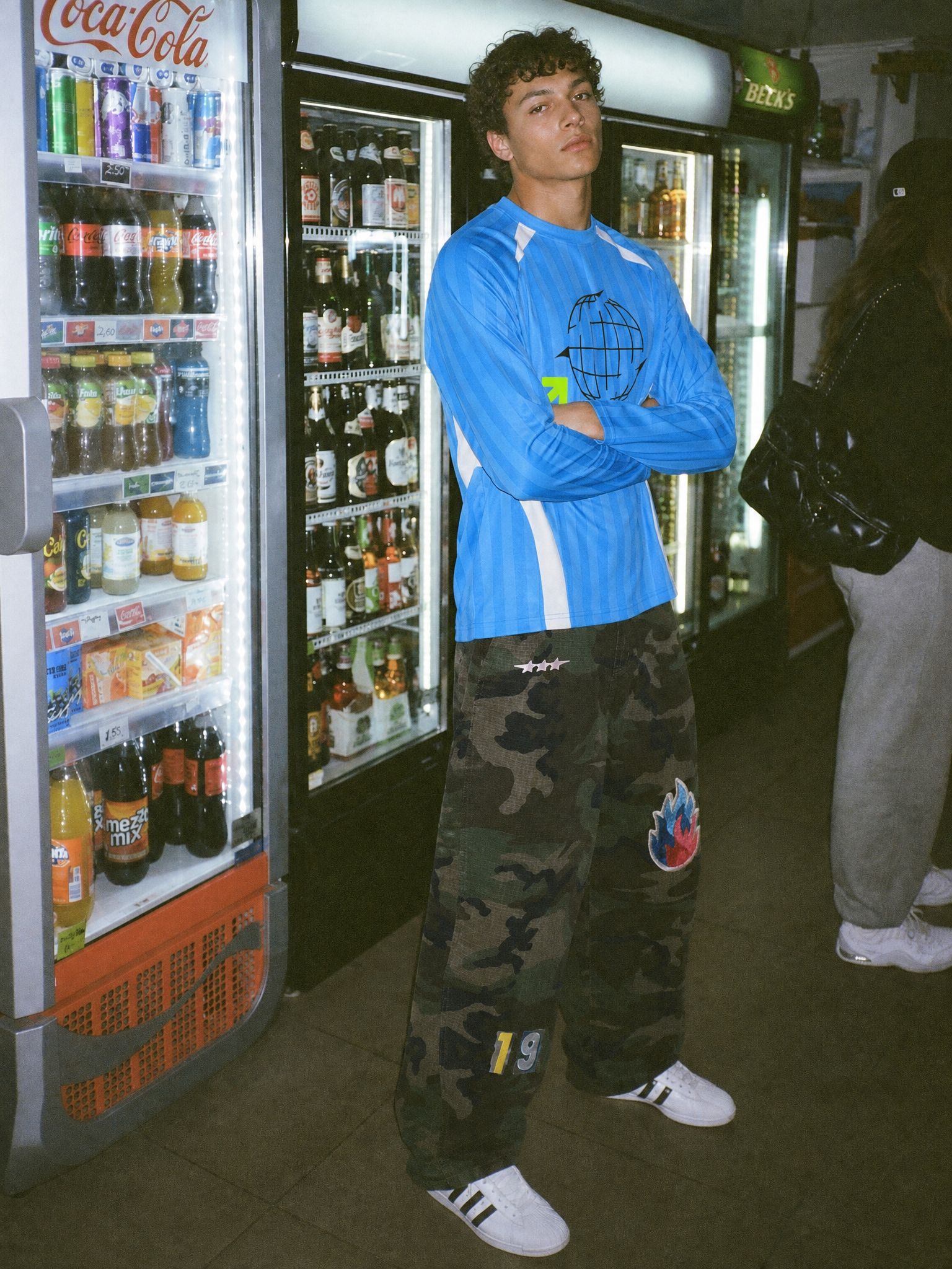 Model wearing a custom long-sleeve football jersey styled with streetwear
