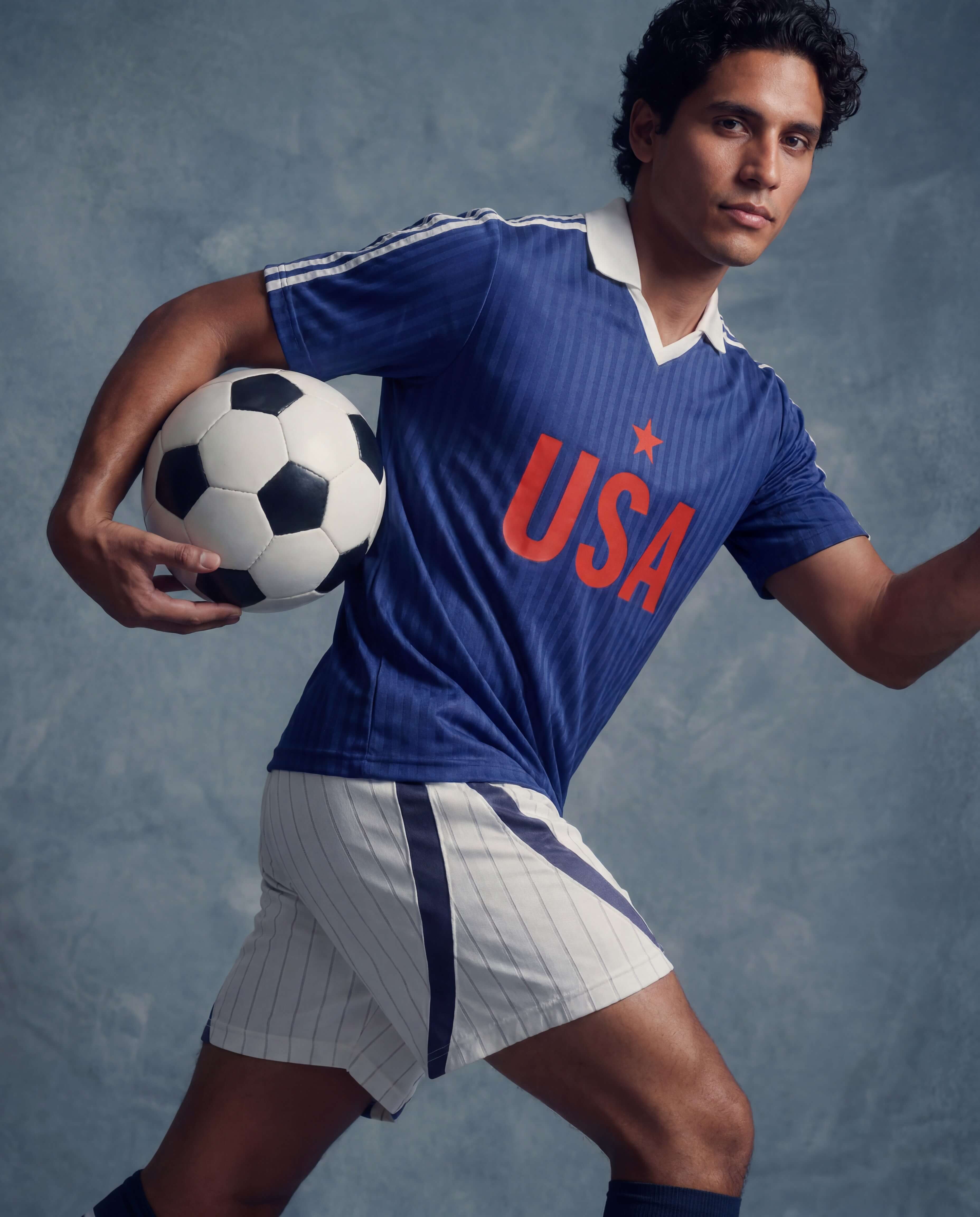 Model wearing a collared football-inspired jersey with matching athletic shorts