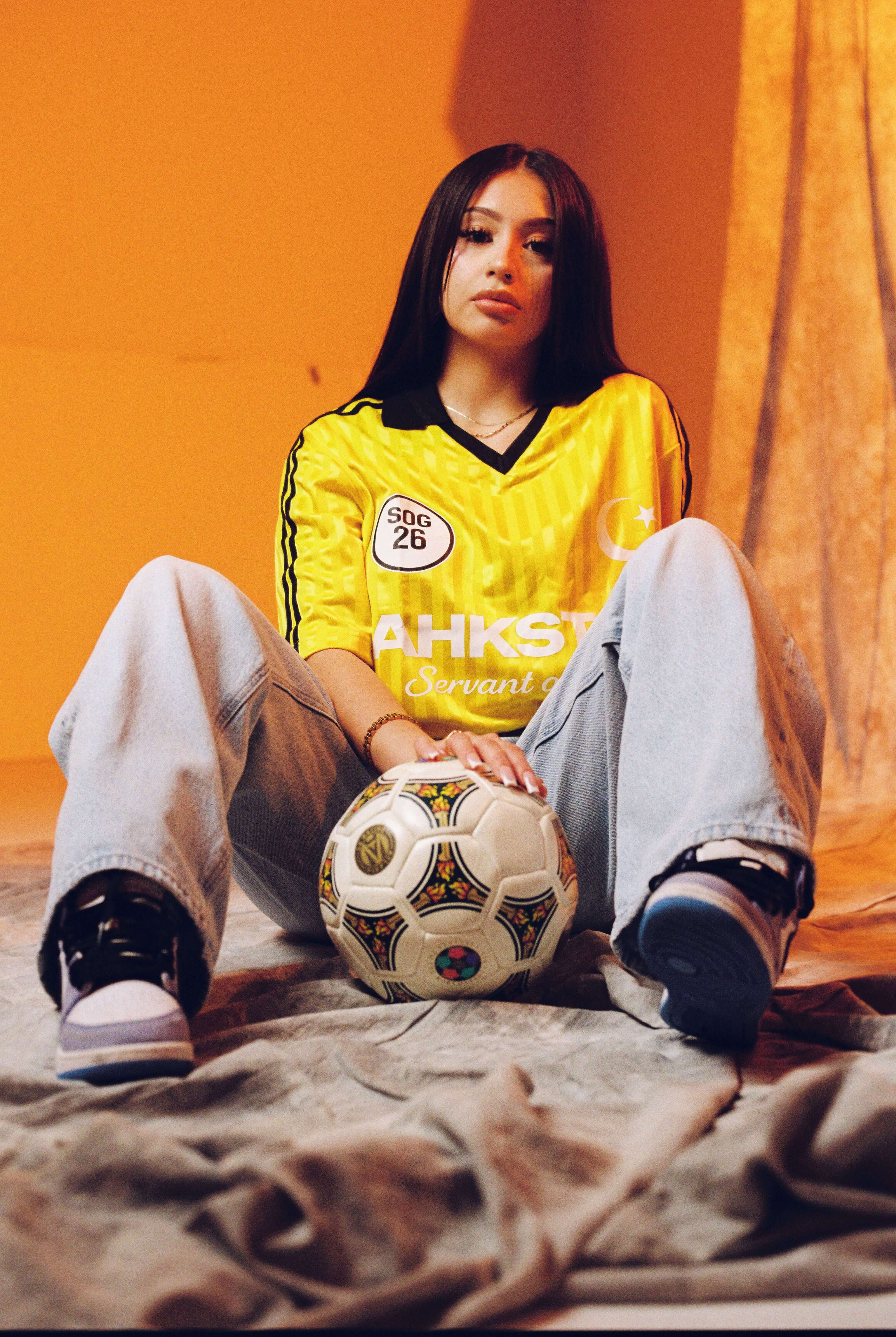 Model wearing Ahkstar's custom football-inspired jersey with branded graphic design
