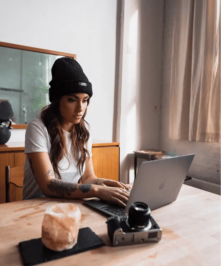 Video creator recording content at home using a laptop and camera setup